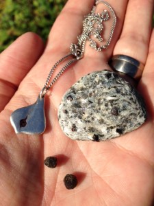 Två granater, en sten med granter i och mitt halsband med en granat från Abisko.